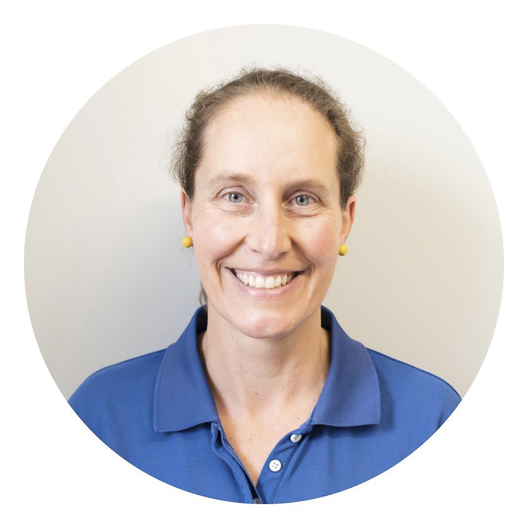 Staff photo of Erica Eccleston, wearing an Orange Family Physiotherapy blue polo shirt in front of a plain grey background.