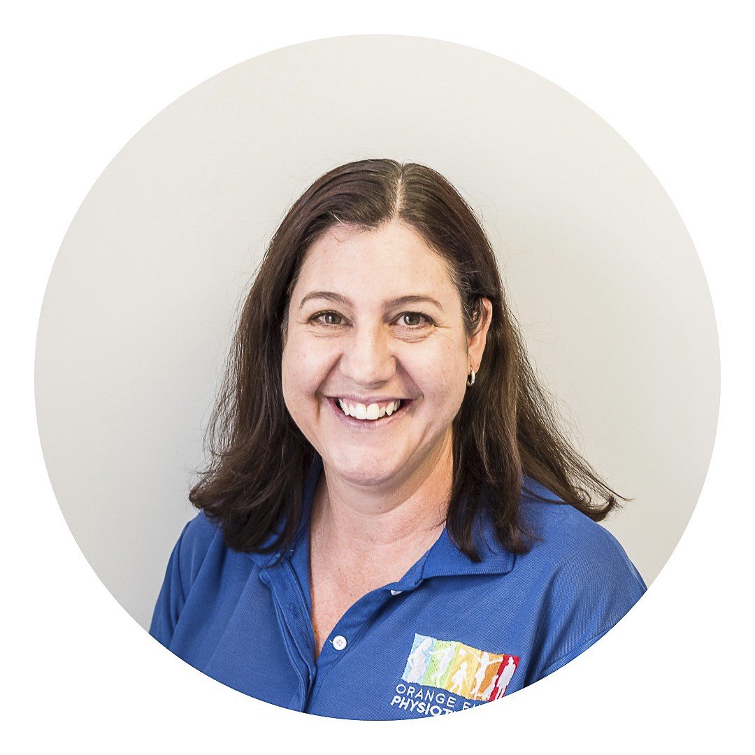 Staff photo of Raelene Carman, wearing an Orange Family Physiotherapy blue polo shirt in front of a plain grey background.
